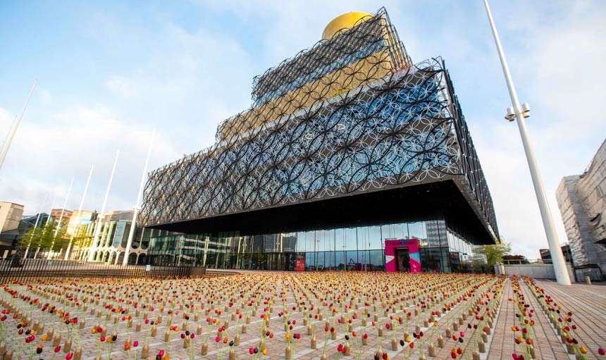 Hundreds of bottles filled with tulips in neat lines outside a landmark in Birmingham.