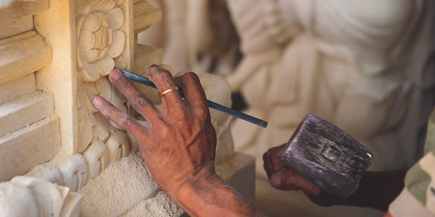 Stonemason working with hammer and chisel