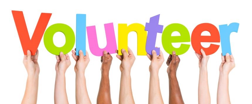 Hands holding up colourful letters that spell volunteer